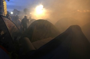 A protester runs through tents covered by tear gas in Gezi park in Istanbul's Taksim square