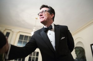 Comedian Stephen Colbert greets a reporter as he arrives for the State Dinner being held for French President Francois Hollande at the White House