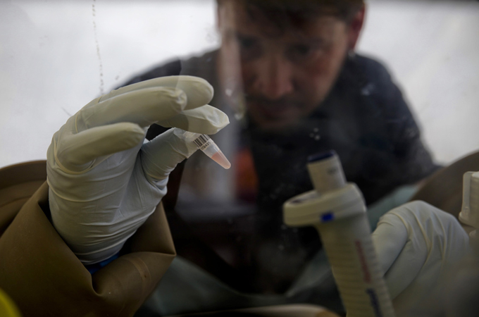 A scientist separates blood cells from plasma cells to isolate any Ebola RNA in order to test for the virus at the European Mobile Laboratory in Gueckedou April 3, 2014. Reuters.