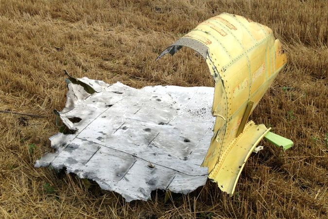 "A piece of wreckage from the Malaysia Airlines jet downed over eastern Ukraine last week shows damage, including shrapnel holes and blistered paint, that is consistent with a hit from a fragmenting warhead, according to consultants with IHS-Jane’s." Photo: Noah Sneider, via NYT