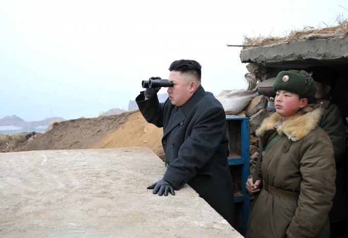 North Korean leader Kim Jong-Un (C) uses a pair of binoculars to look towards the South during his visit to the Jangjae Islet Defence Detachment and Mu Islet Hero Defence Detachment on the front, near the border with South Korea, southwest of Pyongyang March 7, 2013 in this picture released by the North's official KCNA news agency in Pyongyang.